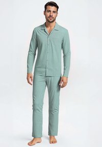 Heren pyjama-set met lange mouwen in teal met verticale strepen. Bevat een overhemd met knopen, een borstzak en bijpassende rechte broek. Zacht materiaal.