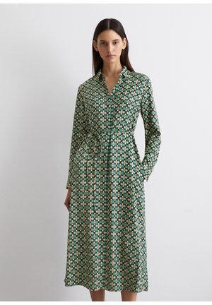 Vestito verde a fantasia con maniche lunghe, colletto e tasche. Presenta disegni geometrici in tonalità gialle, crema e verde scuro.