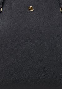 Saco de tecido preto com uma superfície texturizada, apresentando um logo dourado "RLL". O design inclui duas alças e mínimos detalhes em metal.