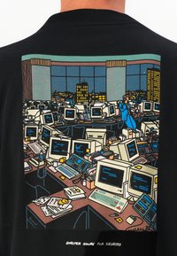 Tricou din material negru, prezentând o grafică colorată a unei birouri aglomerate, cu mai multe calculatoare vintage, documente și o figură îmbrăcată într-un costum albastru.