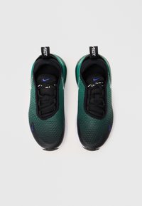 Žalios ir juodos sportinės bateliai su tekstūruotu tinkliniu viršumi, lygiais sintetiniais akcentais ir matoma baltos spalvos padais. Nike logotipas šonuose ir liežuvėlyje.