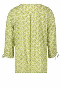 Blusa verde con un motivo geometrico in tonalità chiare e scure, orlo arricciato e maniche a tre quarti con dettagli a fiocco.