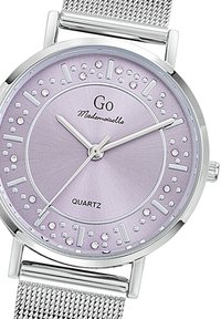 Montre en quartz argentée avec un fond lilas, index en cristaux et bracelet en maille argentée. Présente un cadran à texture lisse et un design minimaliste.
