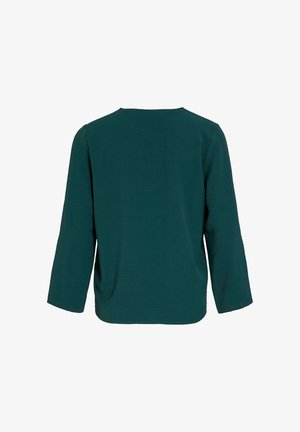 Türkis pikk kollane särk, mis on valmistatud tekstuuriga kangast. Omab ümmargust kaelust ja vabalt põimitud lõiget, kukkuvate õmblustega õlgadel, ilma nähtavate sulgurdeta.