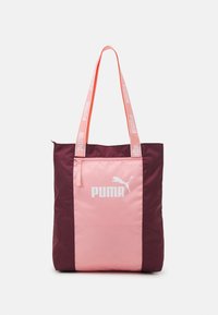 Bolso tote con un diseño en rosa y burdeos, que presenta un bolsillo delantero con cremallera, impresión de logo y asas cortas hechas de tela de marca.