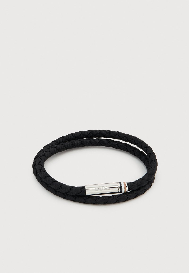 Μαύρο πλεκτό βραχιόλι διπλής περιέλιξης με ασημένιο μαγνητικό κούμπωμα χαραγμένο με τη λέξη «BOSS» σε απλό φόντο.