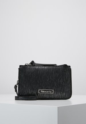 Borsa a tracolla nera con trama, dotata di chiusura con zip, caratterizzata da una placca con logo in argento, una tracolla rimovibile e una forma rettangolare.