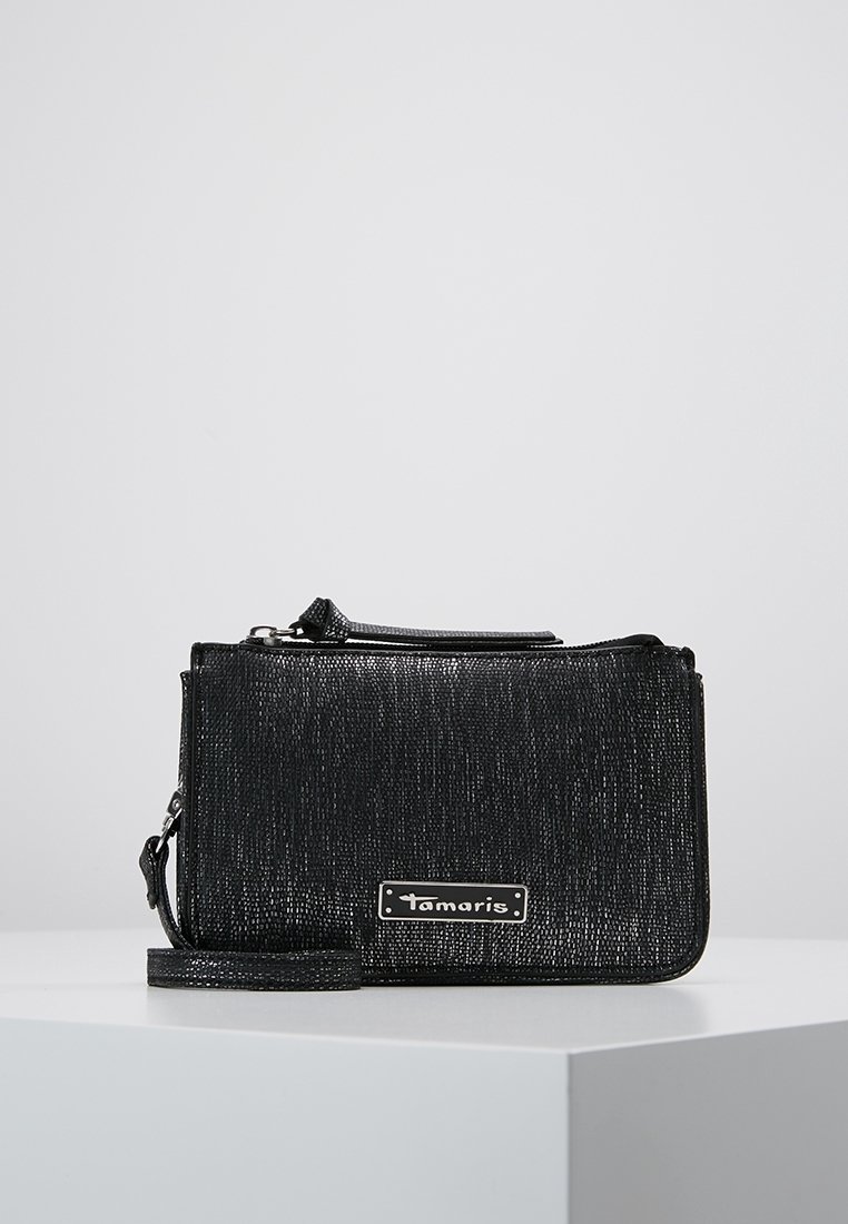 Svart texturerad axelväska med dragkedjestängning, utrustad med en silverfärgad logoplåt, avtagbar rem och rektangulär form.