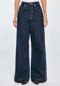 Temno modri široki jeans hlače iz denima, z zlatim šivom, sprednjimi žepi in visoko pasom z gumbom.