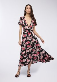 Abito nero a fiori con maniche a farfalla corte, scollatura a V profonda e gonna fluida caratterizzata da motivi floreali rosa e bianchi.