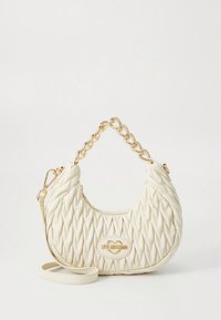 Vadderad cremefärgad handväska med böjd siluett, handtag i guldkedja, avtagbar axelrem och en logoplakett på framsidan.