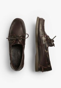 Dunkelbraune Lederboote mit Schnürsenkeln, ein Schuh von oben und der andere von der Seite gezeigt, auf weißem Hintergrund isoliert.