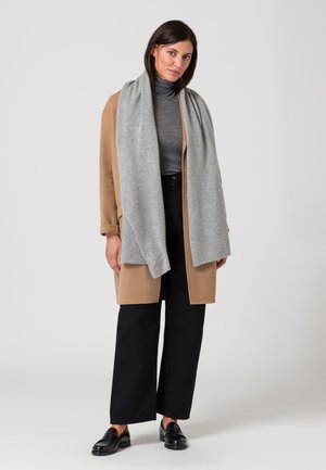 Beige cardigan met een grijze sjaal, grijze coltrui, zwarte wijde broek en zwarte loafers. Zachte texturen, relaxte pasvorm, minimalistisch ontwerp.