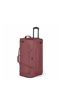 Sac de voyage souple vertical de couleur rose foncé avec poignée rétractable noire, poches latérales zippées et sangles de transport.