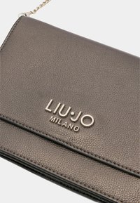 Šedá texturovaná kožená peněženka se stříbrným logem "LIU•JO MILANO" výrazně zobrazeným. Disponuje elegantním designem a detailním prošíváním.