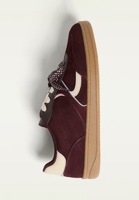Sneaker in suede color marsala con suola in gomma testurizzata, caratterizzato da dettagli in crema e lacci a fantasia, progettato con una silhouette a bassa altezza.