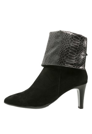 Botte de cheville en daim noir avec un col en imprimé serpent noir brillant. Dotée d'un bout pointu et d'un talon slim et haut. Texture lisse, design élégant.