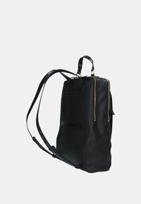 Zaino in pelle nera con due scomparti con zip, manico superiore e spallacci regolabili con accessori in tonalità oro.