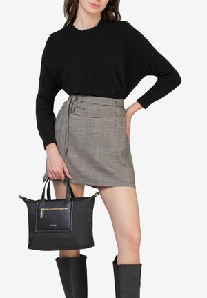 Suéter negro de gran tamaño, falda corta de cuadros grises con un lazo lateral, bolso tote negro con un bolsillo con cremallera en la parte delantera, y botas negras hasta la rodilla.