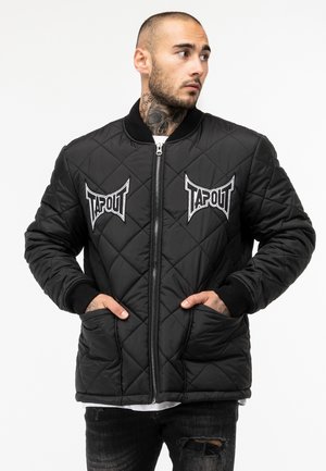 Sort quiltet bomberjakke med ribstrikkede manchetter og kanten, prydet med to broderede Tapout-logoer på brystet og sidelommer.