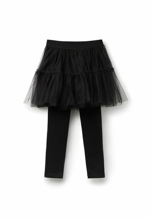Jupe en tulle noir à plusieurs couches attachée à des legging noirs. La jupe présente des volants et une taille élastique. Tissu lisse pour les leggings.