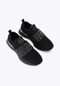 Scarpe sportive nere con upper in rete testurizzata, impreziosite da dettagli neri lucidi e una fascia decorativa al centro.