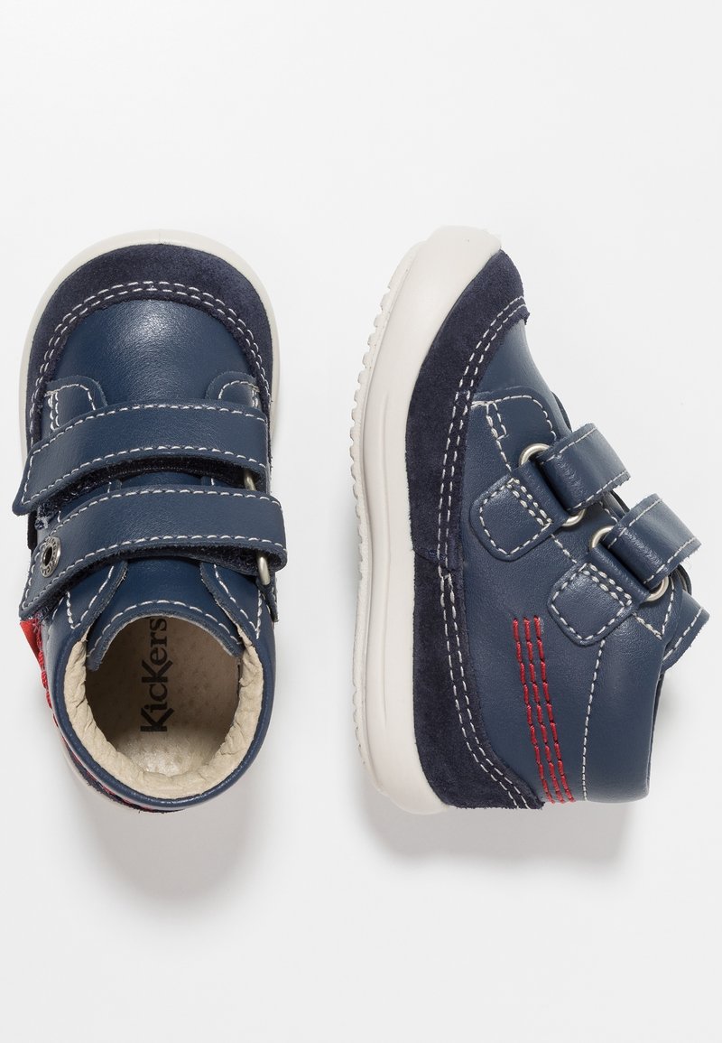 Chaussures pour enfants bleu marine avec bandes velcro, mélange de cuir et de daim, semelle en caoutchouc blanche, accents de couture rouges.