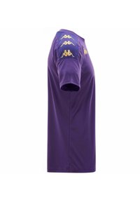Jersey de manga corta morado hecho de una tela suave. Presenta detalles en oro en los hombros. Diseño sencillo con un ajuste clásico.