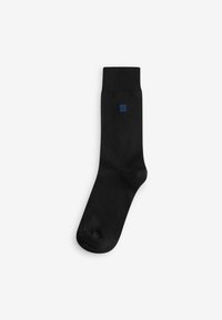 Black cotton sock with ribbed cuff, featuring a small blue logo detail near the ankle. Smooth texture, standard crew length.
