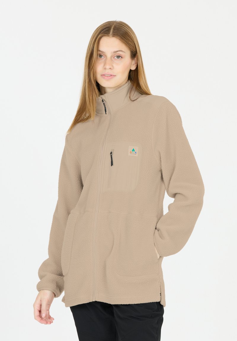 Beige fleecejakke med fuld lynlås, opretstående krave, lynlåslomme på brystet, sidelommer og et logo-patch på venstre side. Glat tekstur.