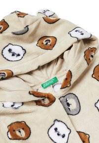 Beżowa bluza z polaru z wzorami niedźwiedzi w różnych kolorach, wyposażona w kaptur i zieloną metkę marki wewnątrz. Miękka tekstura, zabawny design.