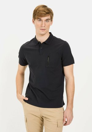 Mørkeblå polo shirt lavet af bomuld med krave, korte ærmer og en frontlomme med lynlås. Enkelt design uden mønstre.