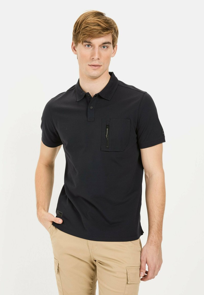 Donkerblauwe polo shirt van katoen met een kraag, korte mouwen en een voorzak met ritssluiting. Eenvoudig ontwerp zonder patronen.