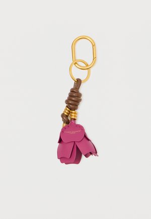 Keychain with gold metal carabiner, brown leather coils, and pink leather flower petals. Features branding on petal surface.