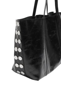 Czarna skórzana torebka typu tote o wyraźnie zarysowanym kształcie. Zawiera okrągłe, srebrne ćwieki po jednej stronie oraz dwa solidne uchwyty do noszenia.