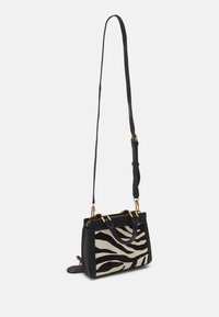 Bolso con patrón de cebra en blanco y negro, de diseño estructurado, con acentos de hardware en dorado y correa de hombro removable.