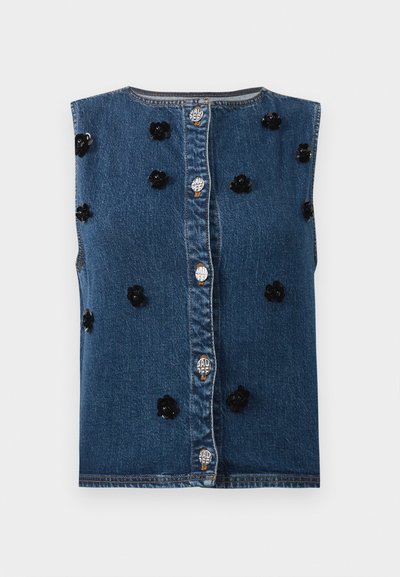 Denim brezrokavnik z zapiranjem na gumbe spredaj. Ima črne cvetne aplike in kontrastne kovinske dele na modri tkanini.