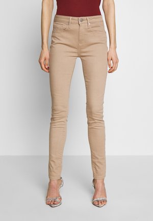Jeans skinny beige de cintura alta, hechos de una mezcla de algodón, con cinco bolsillos y cierre frontal con botón.