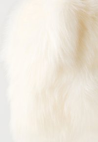 Umelá kožušina v jemnej bielej farbe s dlhým, nadýchaným vlasom a hladkým povrchom. Ideálna na teplé oblečenie alebo doplnky.