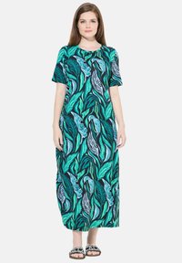 Robe maxi avec un imprimé vert feuillage et bleu sur fond noir, à manches courtes, col rond, avec une coupe décontractée et un design fluide.