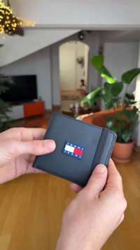 Μαύρο δερμάτινο πορτοφόλι με λογότυπο «Tommy Jeans» σε μπλε, κόκκινο και λευκό. Συμπαγής σχεδιασμός με ραμμένη άκρη και ελαστική ταινία.