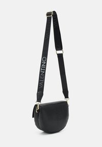 Svart crossbody-veske med teksturert overflate, halvsirkel-form, gullfester og en stropp med "VALENTINO" i hvit tekst.