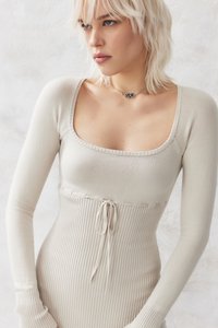 Abito a maglia a coste beige con maniche lunghe, scollatura quadrata e dettaglio con coulisse in vita. Texture morbida, silhouette aderente, design minimalista.