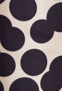 Tessuto con grandi cerchi solidi di colore blu scuro su uno sfondo beige chiaro. La texture appare liscia con una finitura simile al cotone.