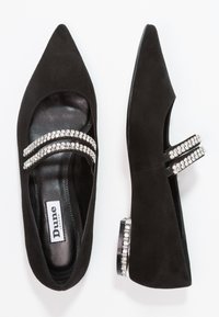 Bailarinas de ante negro con puntas afiladas, que cuentan con dos bandas de cristal brillantes en la parte superior y un pequeño tacón cuadrado adornado con cristales.