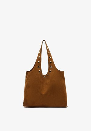 Sac cabas en daim marron avec double poignée décorée de clous métalliques ronds dorés le long des anses et du bord supérieur.
