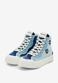 Vysoké tenisky s bílými podrážkami, bílými tkaničkami, dvoubarevnými modrými denimovými panely a černou květinovou výšivkou na bocích.