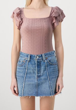 Helles pinkes Spitzen-Bodysuit mit kurzen Rüschärmeln kombiniert mit einem verblassten blauen Jeans-Minirock mit fransigem Saum und vorderen Taschen.