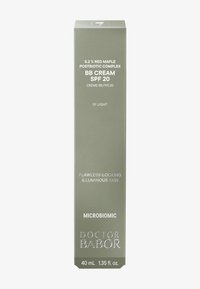 Scatola di crema BB con un esterno verde olivo opaco, testo bianco e accenti argentati. Contiene 40 mL, SPF 20 e promette di migliorare la luminosità della pelle.