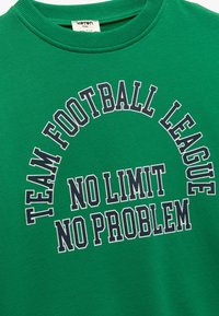 Groene katoenen sweatshirt met geribbelde ronde hals. Bevat de teksten "TEAM FOOTBALL LEAGUE" en "NO LIMIT NO PROBLEM" in marineblauwe bedrukking. Eenvoudig ontwerp.